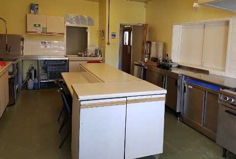 Kitchen showing central preparation area and serving hatch.